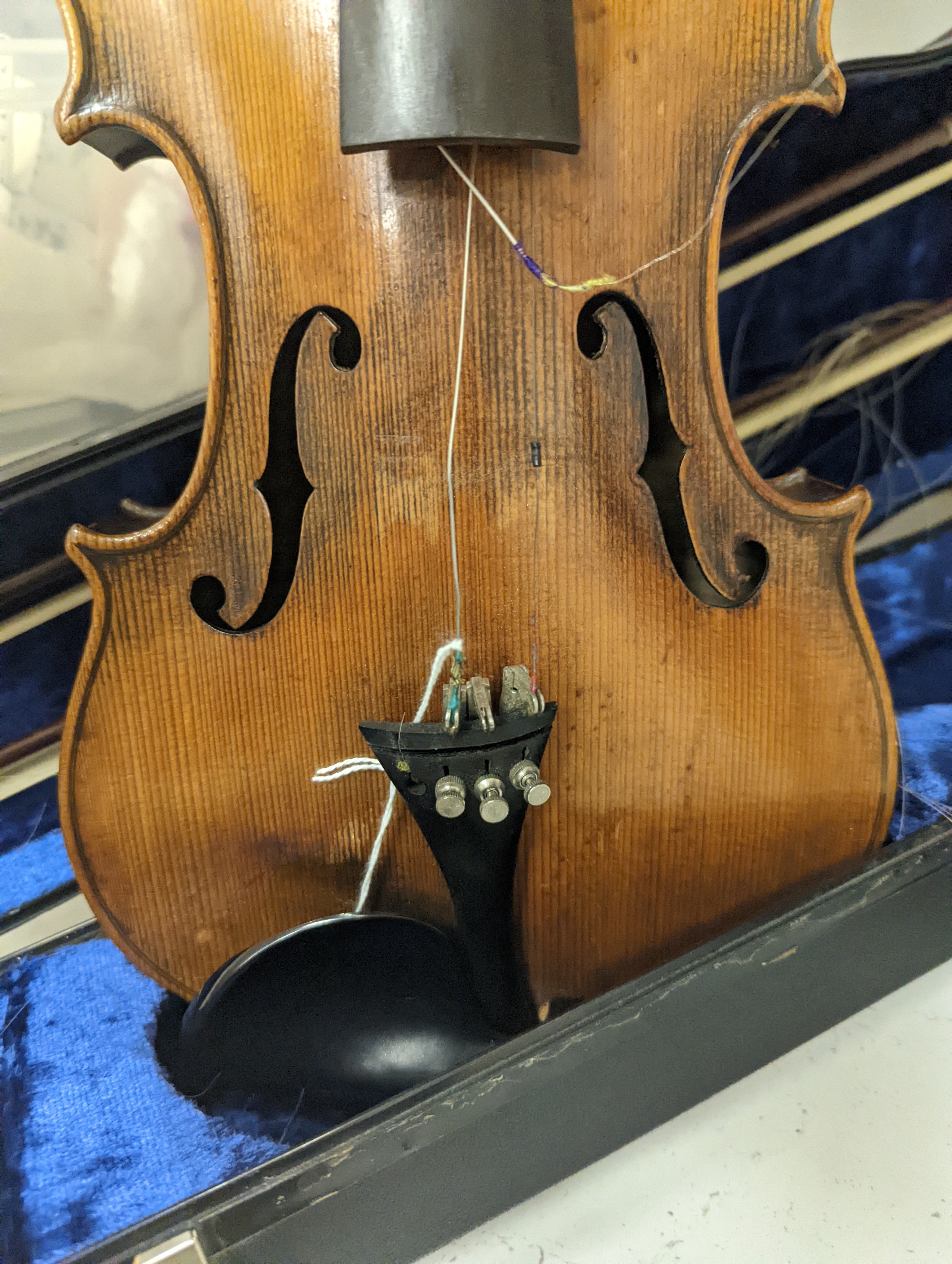 An early 20th century French or English violin with two bows, each stamped